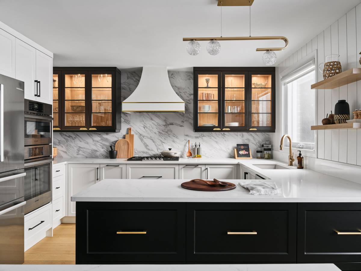 a kitchen with marble counter tops and black cabinets