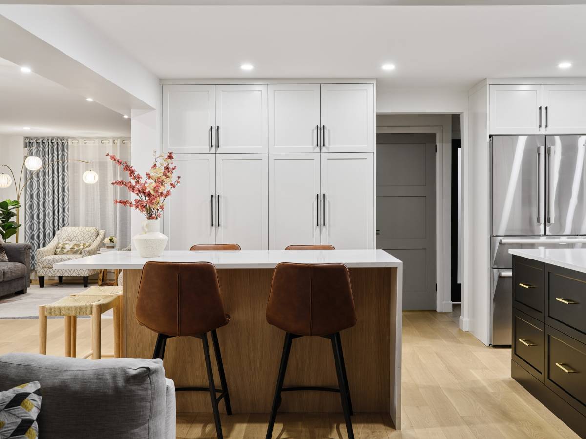 a kitchen with two bar stools next to a central island